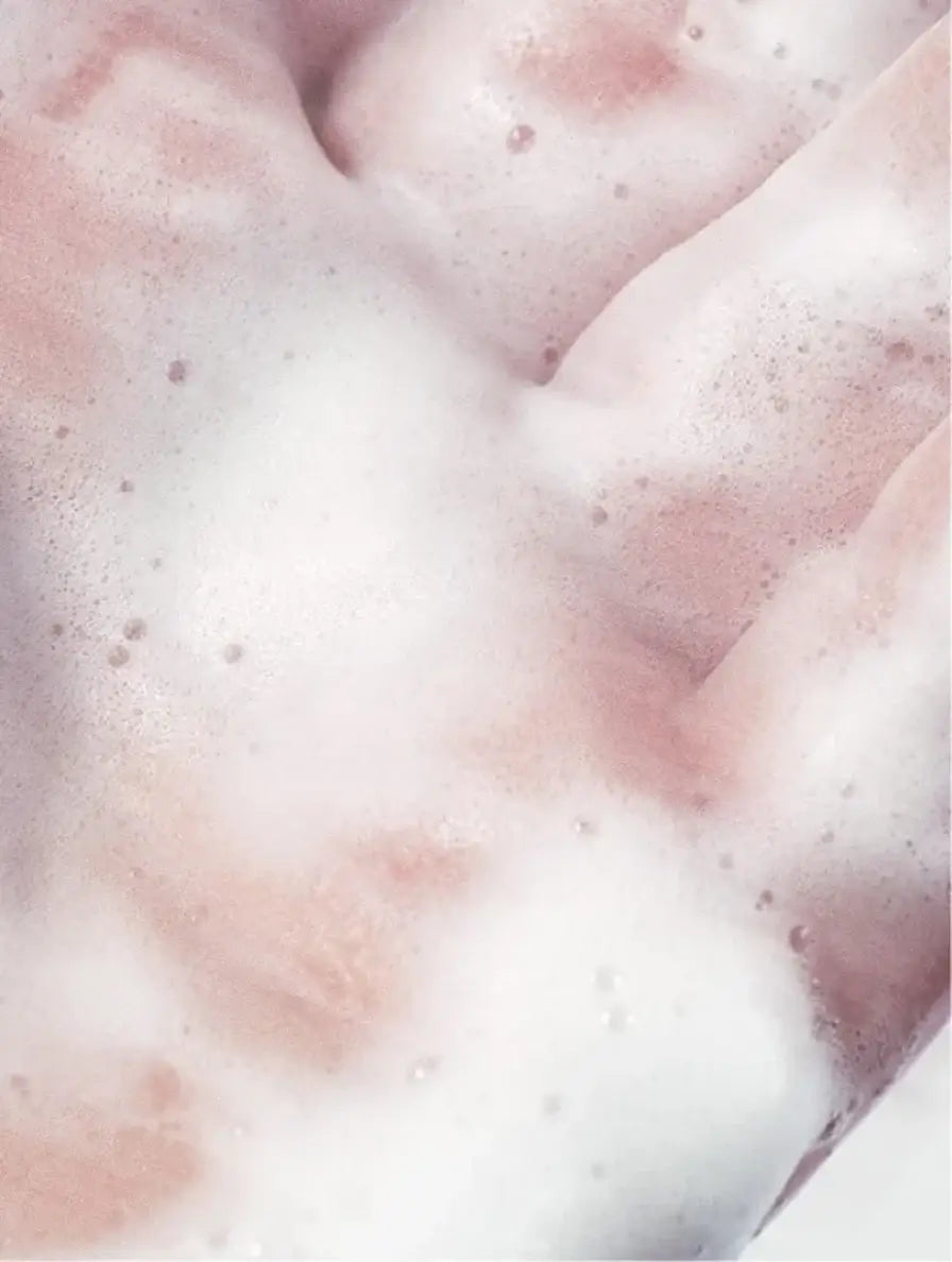 Close-up of foamy texture in a hand, showcasing a purifying toner for skincare.