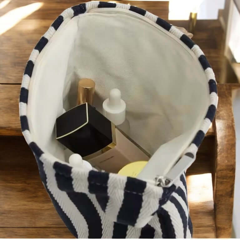 Intérieur de la pochette Novacare avec produits de soins, motif rayé et tissu imperméable.