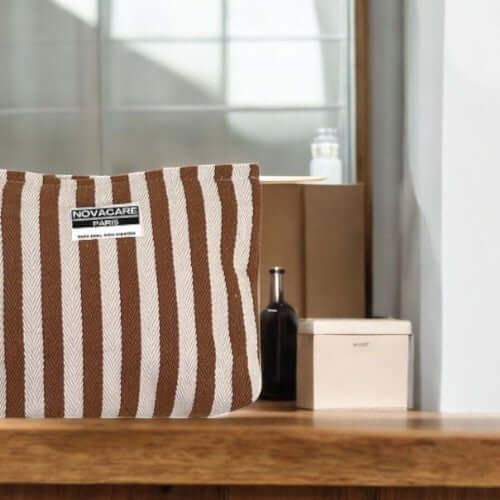 Pochette Novacare à rayures, élégante et imperméable, idéale pour transporter vos essentiels de beauté.